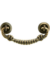 Ornate Brass Bail Pull with Round Rosettes - 3 inch Center-to-Center in Antique Brass Finish.